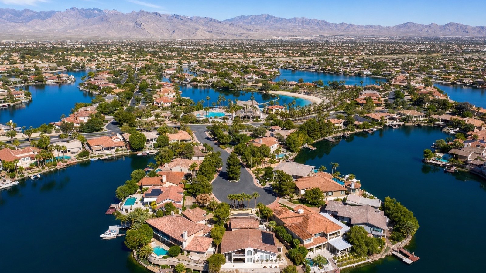 Las Vegas waterfront residential context showing lakefront-frontage homes with private boat dock infrastructure and the desert mountain backdrop